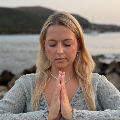 Nina Leismann am Meer, die Hände vor der Brust